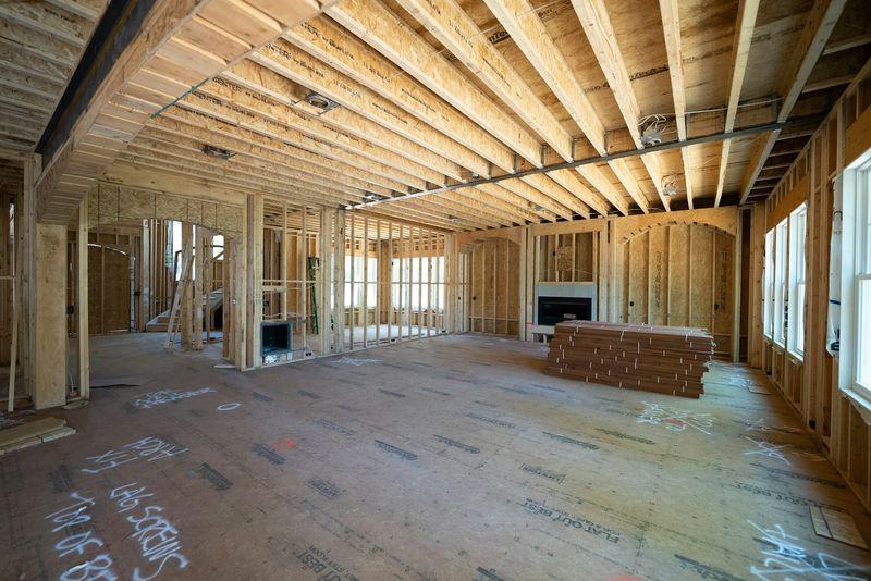 Interior of a newly framed room addition with exposed wood joists and large windows