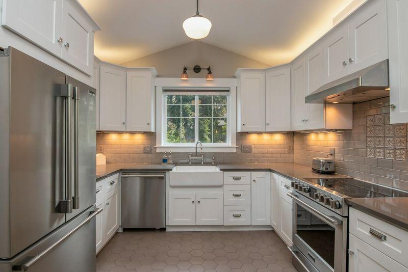 Traditional white kitchen with farmhouse sink, window light and stainless appliances
