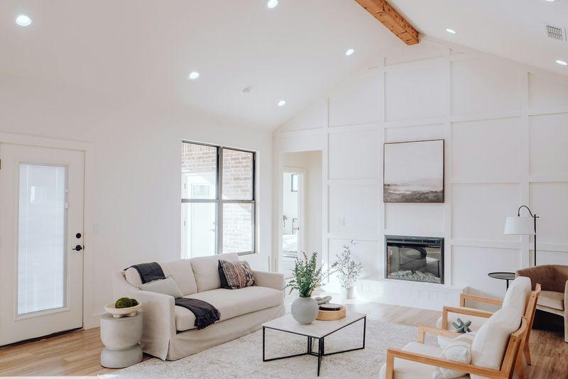 Bright vaulted living room with cream sofa, wood beam, and oak floors