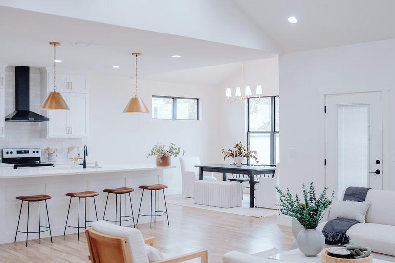 Open-plan kitchen, dining, and living area under a bright vaulted ceiling